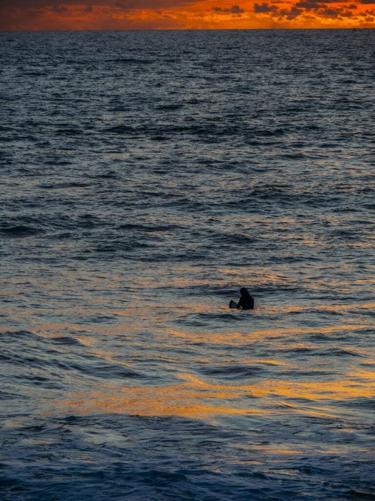 Surfer waiting for a set in the line-up off Canggu